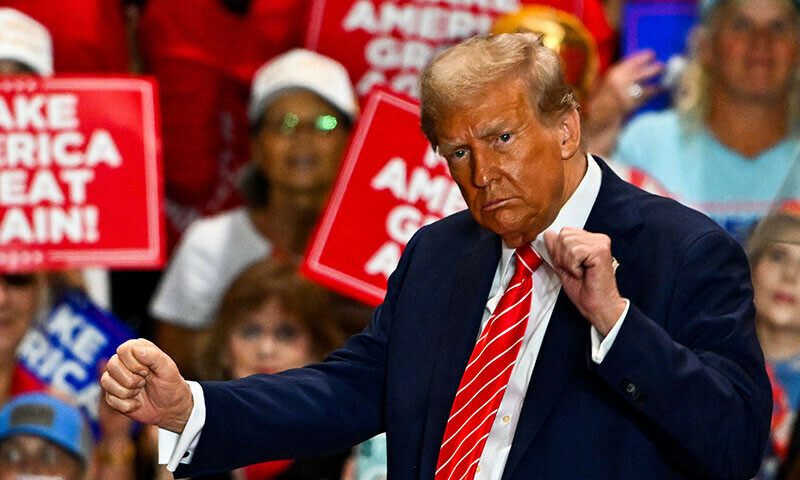 TOPSHOT - Former US President and Republican presidential candidate Donald Trump dances as he leaves a campaign rally in Rocky Mount, North Carolina, on October 30, 2024. (Photo by CHANDAN KHANNA / AFP)
