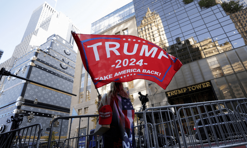  A person waves a Trump flag outside Trump Tower, after Donald Trump won the presidential election, in New York City on November 6. &mdash; Reuters 
