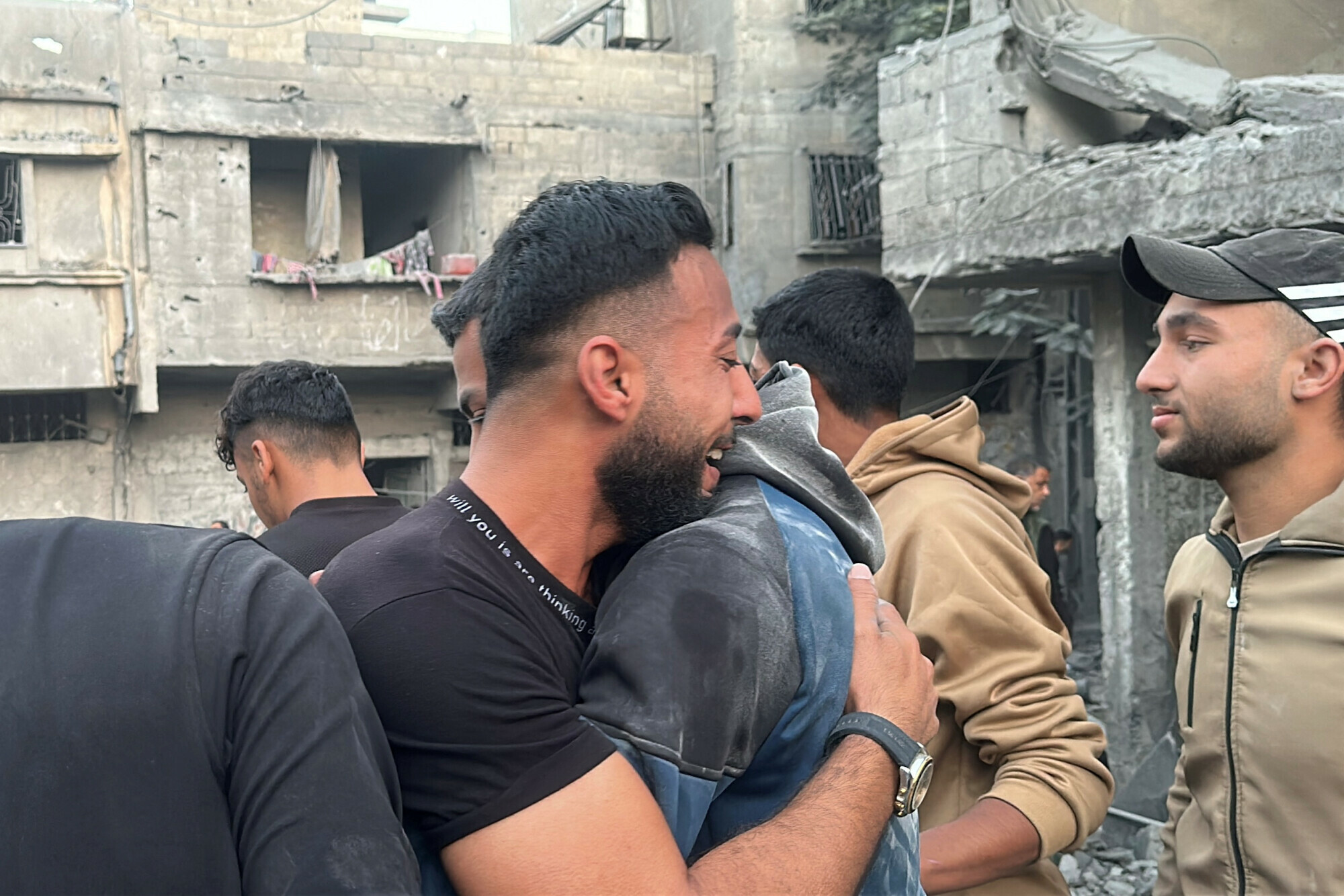 A Palestinian man reacts as he is consoled at the site of an Israeli strike on a house, in Jabalia on November 10. &mdash; Reuters