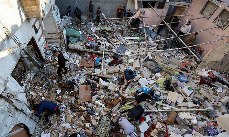 Palestinians inspect the site of an Israeli strike on a house in Nuseirat in the central Gaza Strip on November 13. &mdash; Reuters