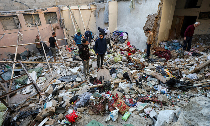 Palestinians inspect the site of an Israeli strike on a house in Nuseirat in the central Gaza Strip on November 13. &mdash; Reuters