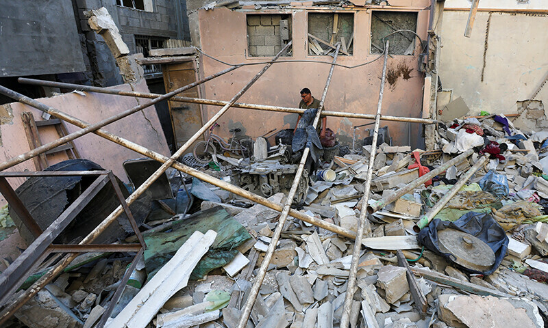 A Palestinian man inspects the site of an Israeli strike on a house in Nuseirat in the central Gaza Strip on November 13. &mdash; Reuters