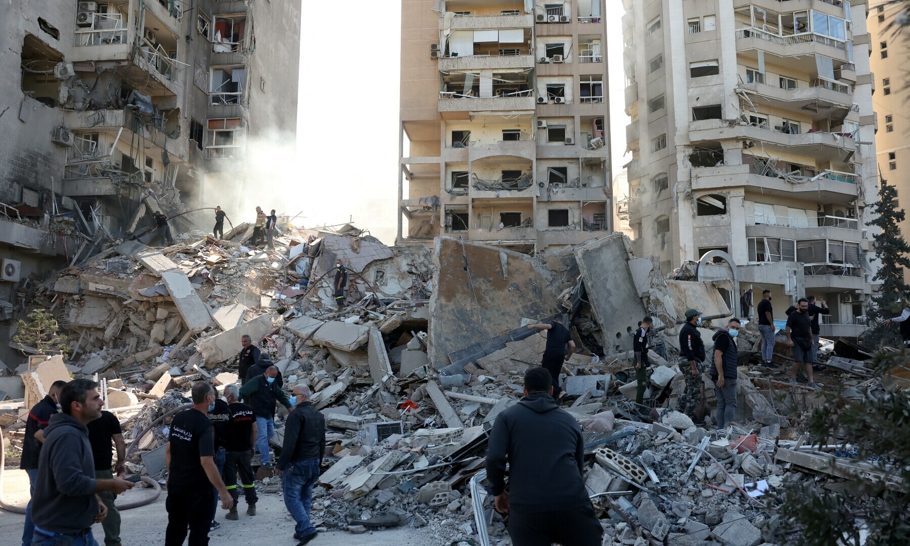  People stand on rubble at a damaged site in the aftermath of an Israeli strike in Tayouneh, Lebanon on November 15. &mdash; Reuters 
