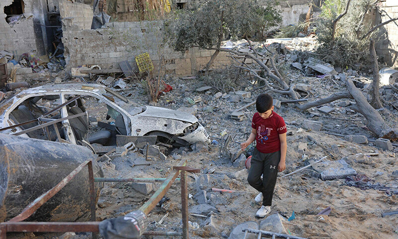 A Palestinian boy walks on the rubble of a house destroyed in an Israeli strike on al-Jalaa street in central Gaza City on November 18. &mdash; AFP