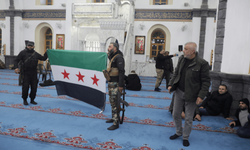 Rebel fighters hold a Syrian opposition flag in Homs after Syria&rsquo;s army command notified officers on Sunday that President Bashar al-Assad&rsquo;s 24-year authoritarian rule has ended, a Syrian officer who was informed of the move told Reuters, following a rapid rebel offensive that took the world by surprise, in Homs, Syria December 8. &mdash; Reuters