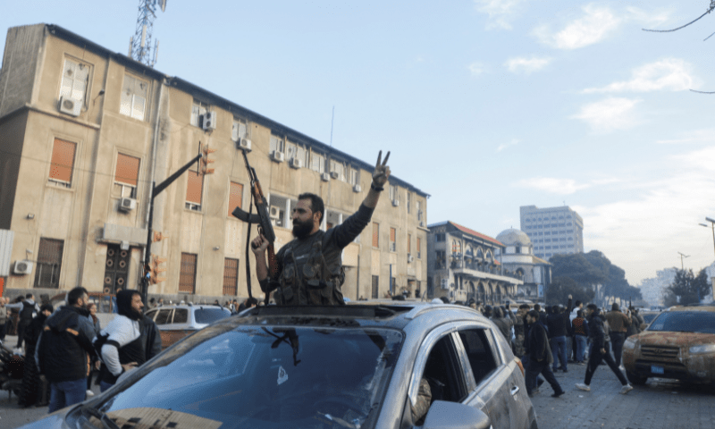 A rebel fighter gestures from a vehicle as they gather in Homs after Syria&rsquo;s army command notified officers on Sunday that President Bashar al-Assad&rsquo;s 24-year authoritarian rule has ended, a Syrian officer who was informed of the move told Reuters, following a rapid rebel offensive, in Homs, Syria December 8. &mdash; Reuters