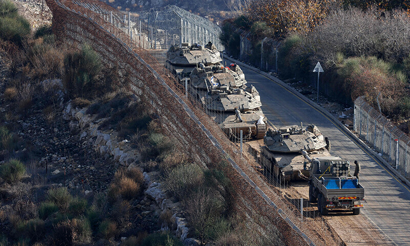 Israeli tanks take position on the border with Syria near the Druze village of Majdal Shams in the Israel-annexed Golan Heights on December 8, 2024. The Israeli military said on December 8, it had deployed forces to a demilitarised buffer zone in southwest Syria abutting the Israeli-annexed Golan Heights after Damascus fell to rebel forces. (Photo by Jalaa MAREY / AFP)