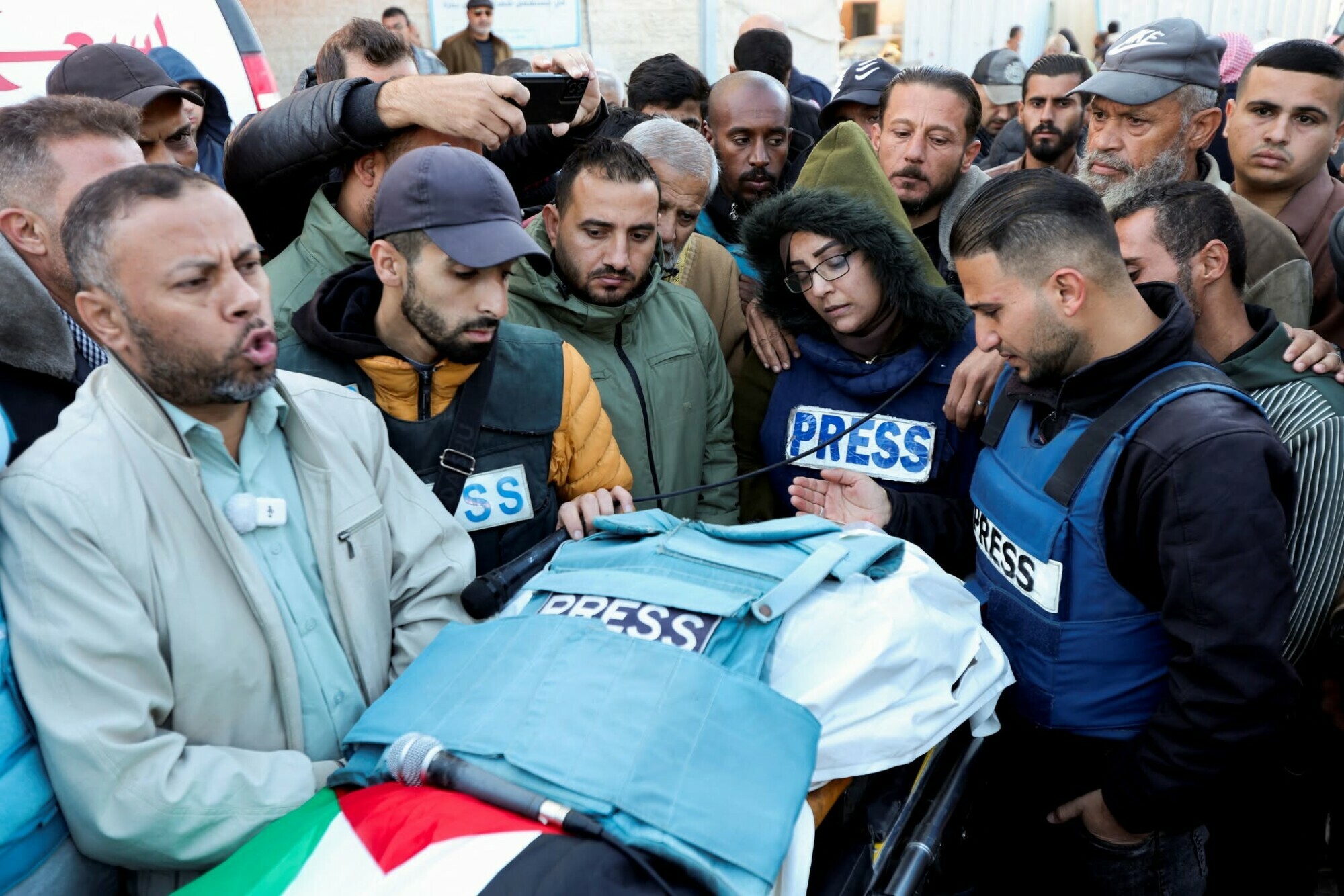 Relatives and colleagues gather around the body of Al Jazeera journalist Ahmad Al-Louh, who was killed along with Civil Defence members in an Israeli strike the day before, during their funeral in Nuseirat on December 16. &mdash; AFP