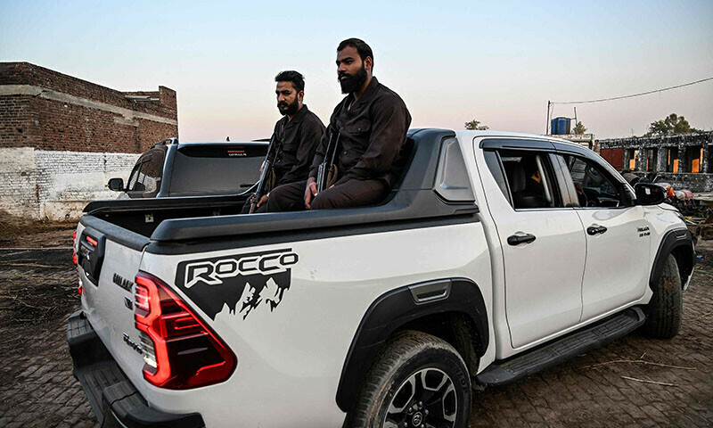 This photograph from November 20 shows armed private security personnel sitting in the back of a Toyota Hilux pickup truck in Gujrat. &mdash; AFP