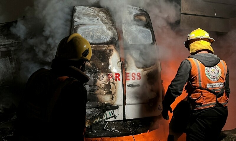 Civil Defence members put out a fire in a broadcast van following an Israeli strike that killed five journalists of <em>Al-Quds Al-Youm</em> television channel, according to medics with the Gaza health authorities, in the vicinity of Al-Awda hospital in Nuseirat in central Gaza on Dec 26, 2024. — Reuters