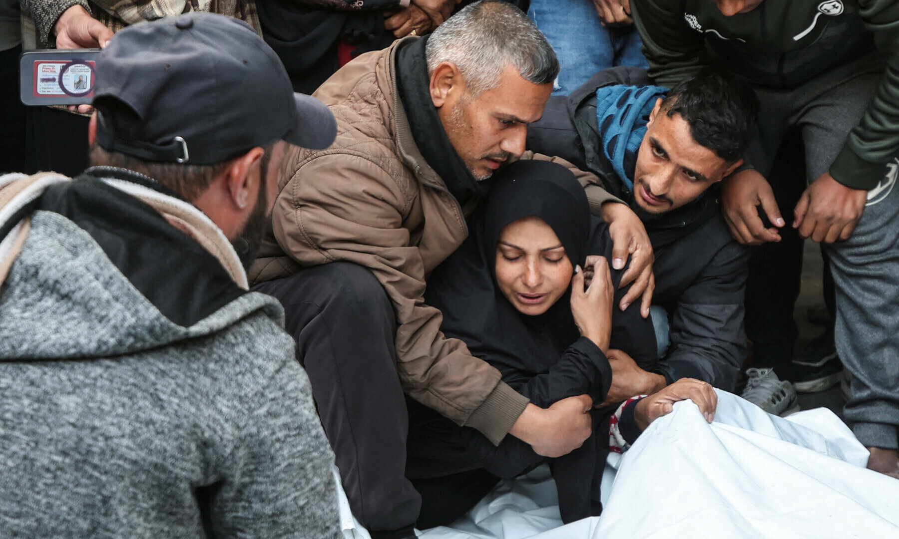  A woman mourns next to bodies during the funeral of Palestinian journalists from <em>Al-Quds Al-Youm</em> television channel who were killed in Israeli airstrikes, according to medics, in Nuseirat, central Gaza strip on Dec 26, 2024. &mdash; Reuters 