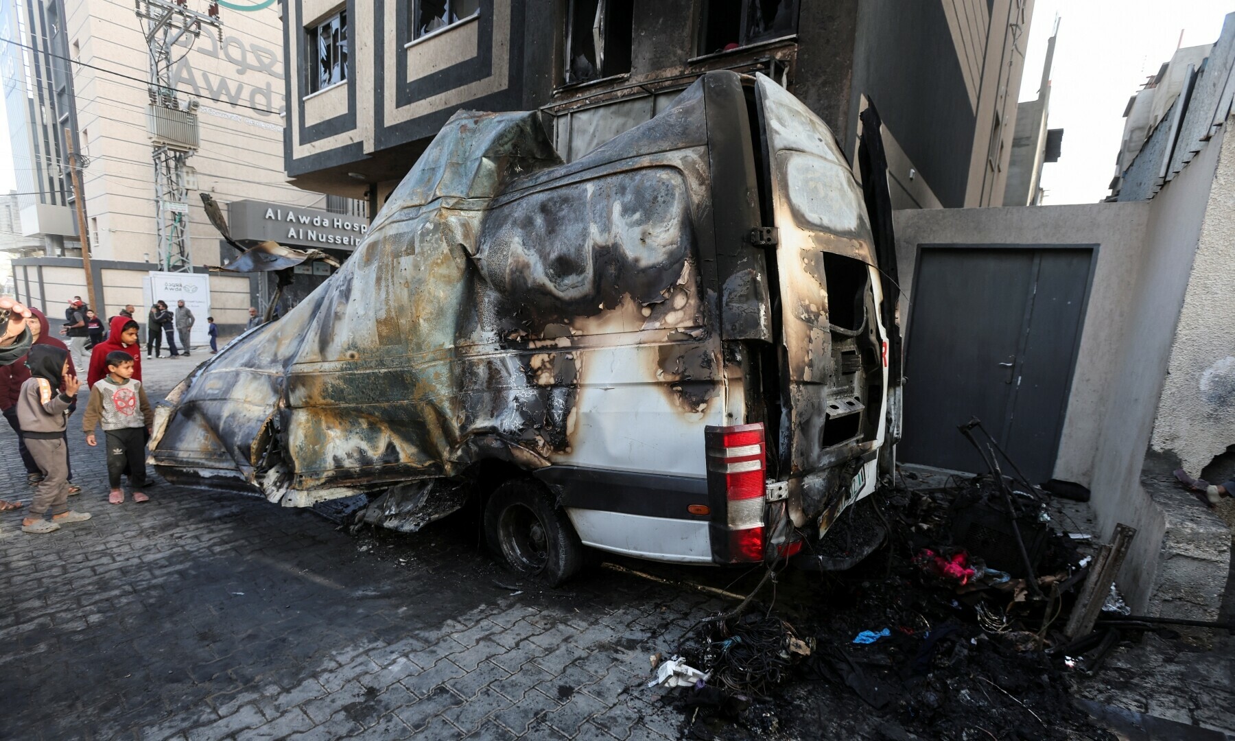  Palestinian children stand near the remains of a broadcasting vehicle following an Israeli airstrike that killed five journalists from <em>Al-Quds Al-Youm</em> television channel near Al-Awda Hospital in Nuseirat, central Gaza Strip on Dec 26, 2024. &mdash; Reuters 