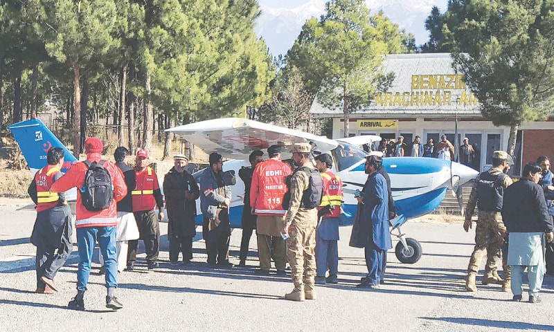 KURRAM: Edhi volunteers and security personnel gather around an aid flight that arrived in Parachinar on Tuesday. The consignment of medicines and other essentials is meant for areas that have been cut off from the rest of the country due to sectarian and tribal tensions, which have claimed dozens of lives.&mdash;AFP