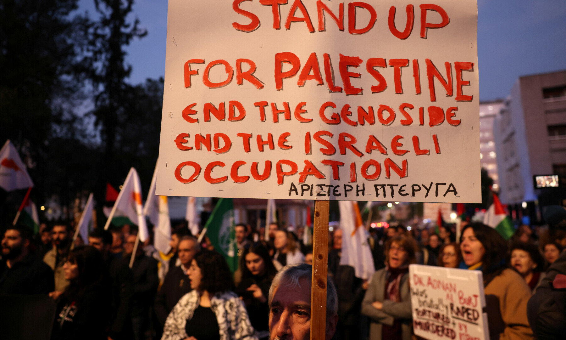  Pro-Palestinian activists hold banners protesting a visit by Israeli President Isaac Herzog outside the Presidential Palace in Nicosia, Cyprus on Jan 9, 2025. &mdash; Reuters/Yiannis Kourtoglou 