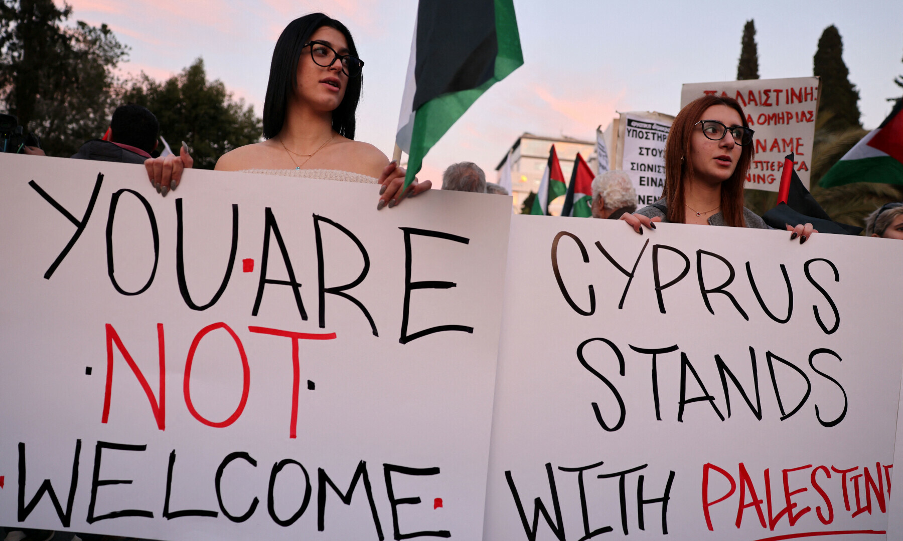  Pro-Palestinian activists hold banners protesting a visit by Israeli President Isaac Herzog outside the Presidential Palace in Nicosia, Cyprus on Jan 9, 2025. &mdash; Reuters/Yiannis Kourtoglou 