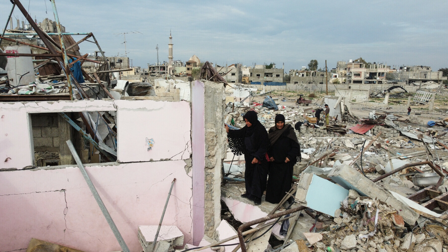 A drone view shows Palestinian women walking amid the rubble of destroyed houses and buildings, following a ceasefire between Israel and Hamas, in Rafah in the southern Gaza Strip on January 22.&mdash; Reuters