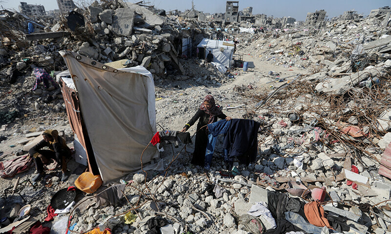  A Palestinian woman spreads out clothes on the rubble of houses and buildings destroyed during the Israeli invasion, amid a ceasefire between Israel and Hamas, in Jabalia refugee camp in the northern Gaza Strip on January 29. &mdash; Reuters 