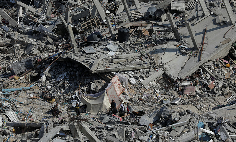  Palestinians stand on the rubble of houses and buildings destroyed during the Israeli invasion, amid a ceasefire between Israel and Hamas, in Jabalia refugee camp in the northern Gaza Strip on January 29. &mdash; Reuters 