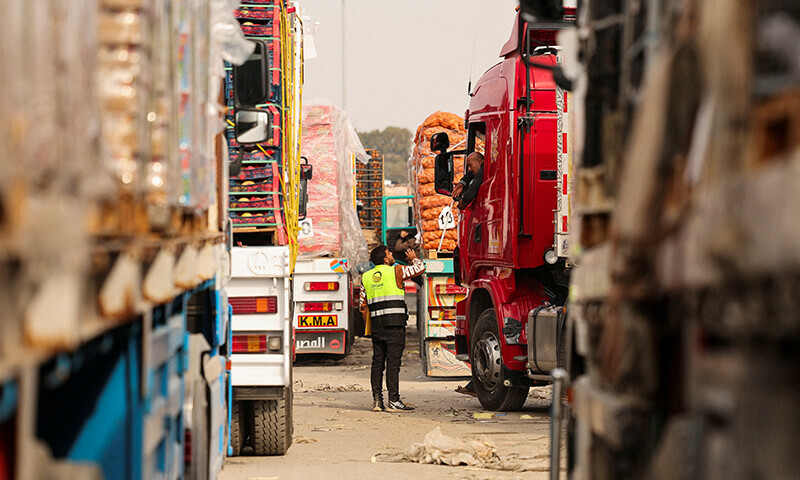 A truck driver talks with a worker as he waits to go through the Rafah border crossing to enter the Gaza Strip, amid a ceasefire between Israel and Hamas, in Rafah, Egypt on January 28. &mdash; Reuters