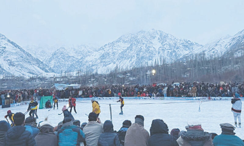 Spectators watch an ice hockey match at Sultanabad village of Yasin during winter festival on Saturday. In the other picture, elders dance on traditional music at the festival. &mdash; Dawn