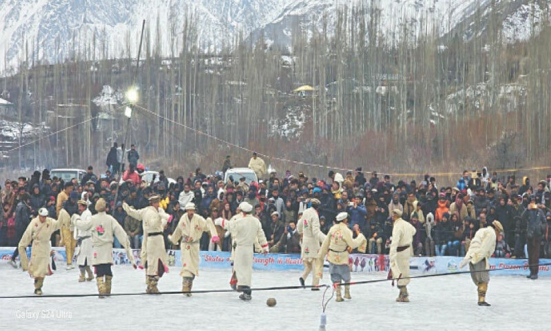Local elders wearing traditional winter dresses play Dapdachum, a local game, in the ice rink at Sultanabad village of Yasin during the winter festival on Saturday. &mdash; Dawn