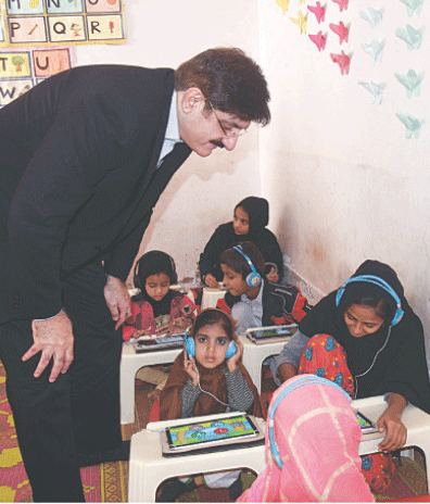 CM Murad Ali Shah interacts with students at a school in Korangi, on Monday.—Dawn