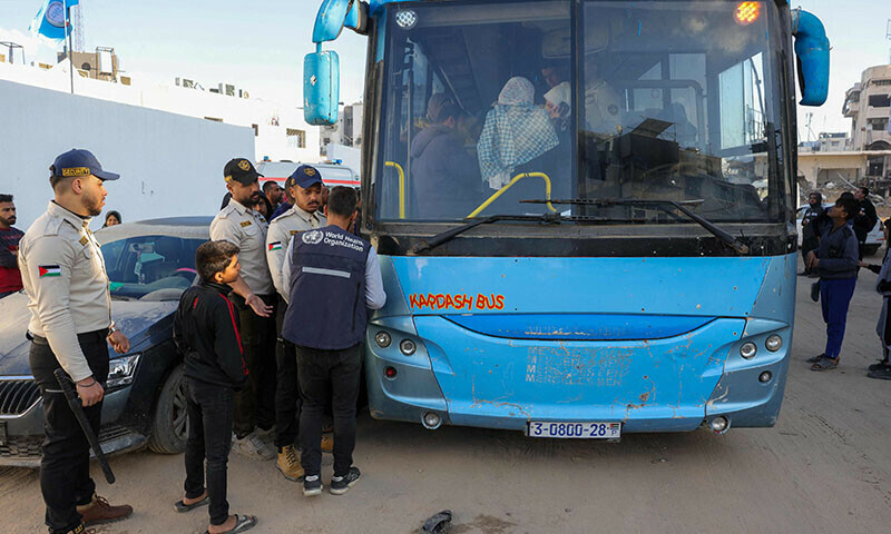  Palestinian security personnel stand next to a bus loaded with patients from Gaza City&rsquo;s Al-Shifa Hospital waiting to be evacuated to Egypt for treatment through the Rafah crossing on February 1. &mdash; AFP 