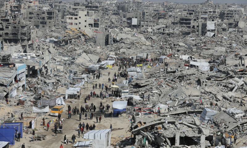 Palestinians walk through the rubble of houses and buildings destroyed during the Israeli offensive, in Jabalia refugee camp in the northern Gaza Strip on January 29.— Reuters