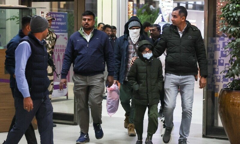 Security personnel escort Indian immigrants deported from the US, as they leave the airport in Ahmedabad, India, February 6. — Reuters