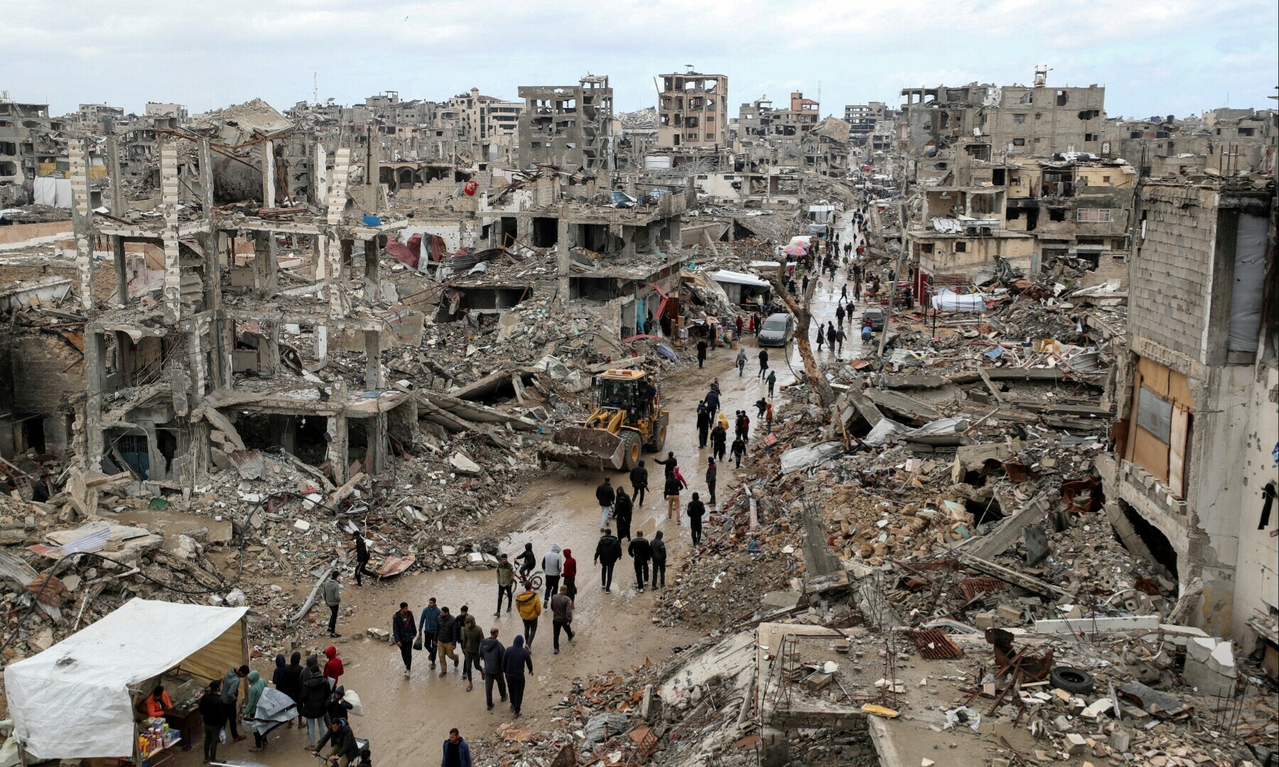 Palestinians walk past the rubble of buildings destroyed during the Israeli offensive, on a rainy day, in Gaza City on Feb 6, 2025. — Reuters/Dawoud Abu Alkas
