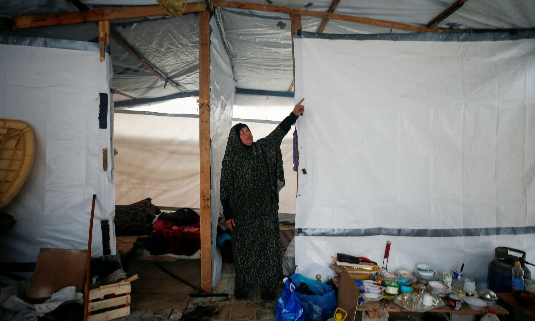  A Palestinian woman points to the cover of her shelter, through which rainwater leaks, amid a ceasefire between Israel and Hamas, in Jabalia refugee camp in the northern Gaza Strip on Feb 11, 2025. —Reuters/Mahmoud Issa 