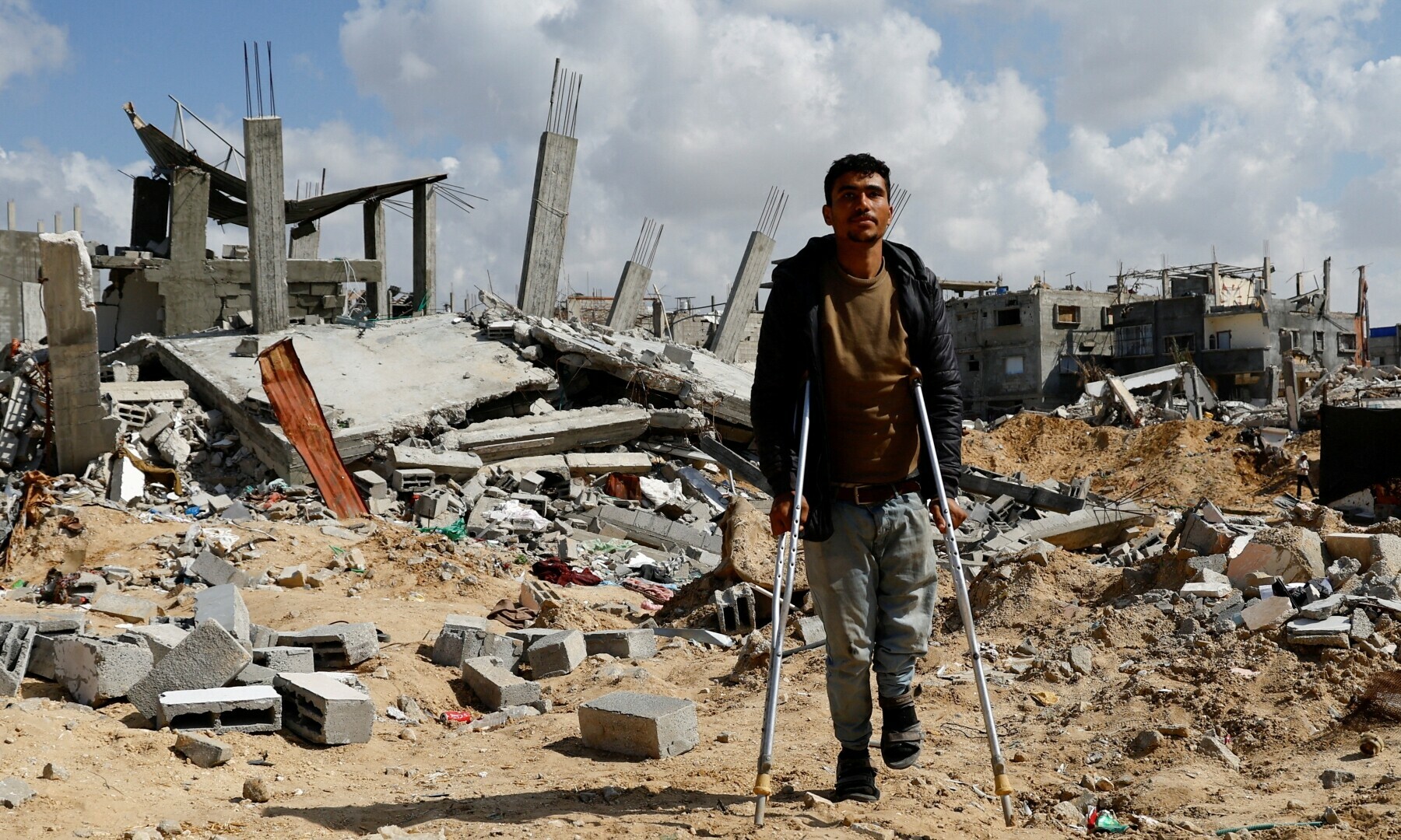 A Palestinian man walks with crutches amidst the rubble of buildings destroyed during the Israeli offensive, in Rafah in the southern Gaza Strip on Feb 16, 2025. — Reuters/Hatem Khaled
