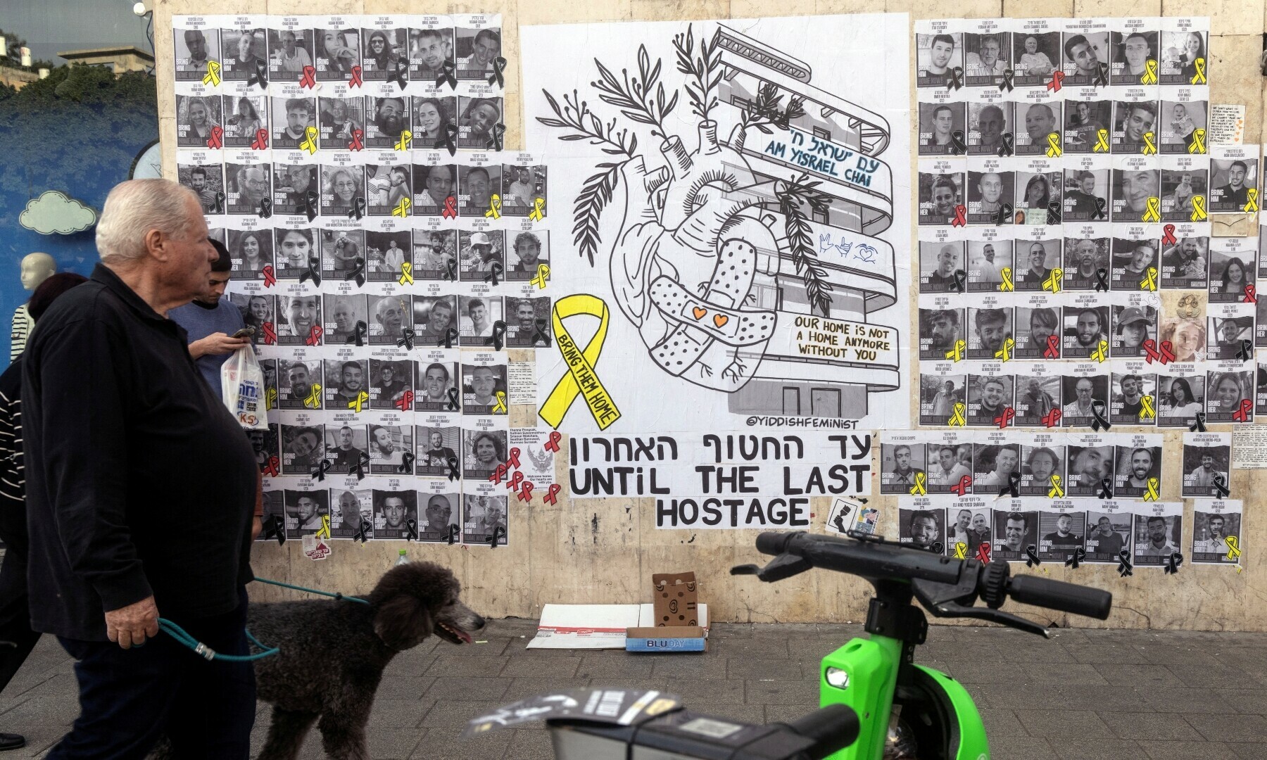  People walk next to a graffiti supporting the release of all hostages who have been held in Gaza since the October 7, 2023 attack, in Tel Aviv, Israel on February 18, 2025. &mdash; Reuters/Nir Elias 