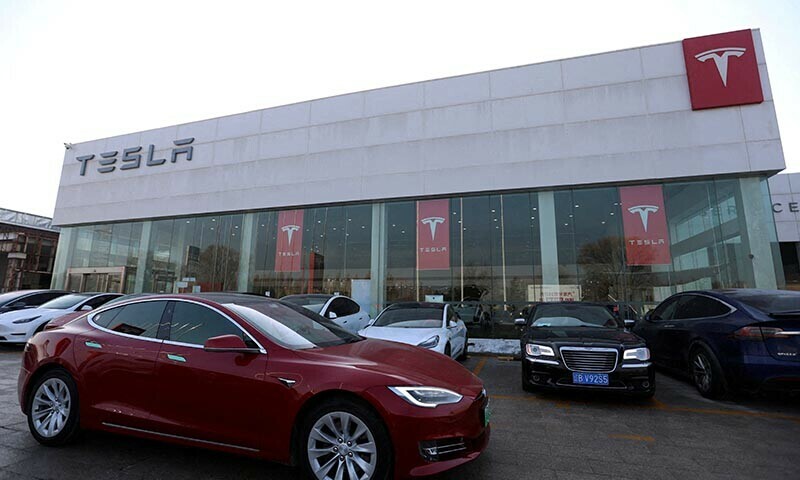 A Tesla car is driven past a store of the electric vehicle maker in Beijing, China, January 4, 2024. &mdash; Reuters File Photo
