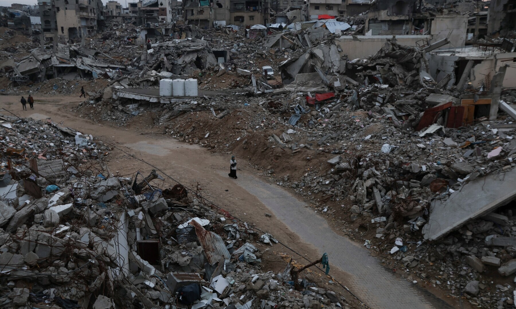 Palestinians walk among the rubble of buildings destroyed during the Israeli offensive, in Khan Younis, in the southern Gaza Strip on Feb 24, 2025. — Reuters/Ramadan Abed