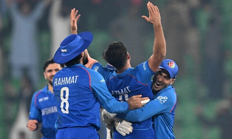 Afghanistan&rsquo;s wicketkeeper Rahmanullah Gurbaz (R) embraces Afghanistan&rsquo;s bowler Azmatullah Omarzai (C) as Afghanistan&rsquo;s players celebrate after winning the ICC Champions Trophy one-day international cricket match between England and Afghanistan at the Gaddafi Stadium in Lahore on February 26. &mdash; AFP
