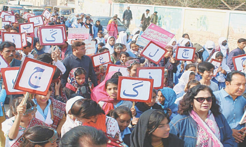 PARTICIPANTS in a walk held by the Sindhi Language Authority as part of its campaign in Qasimabad hold placards inscribed with different letters of Sindhi alphabet, on Saturday.&mdash;Photo by Umair Ali
