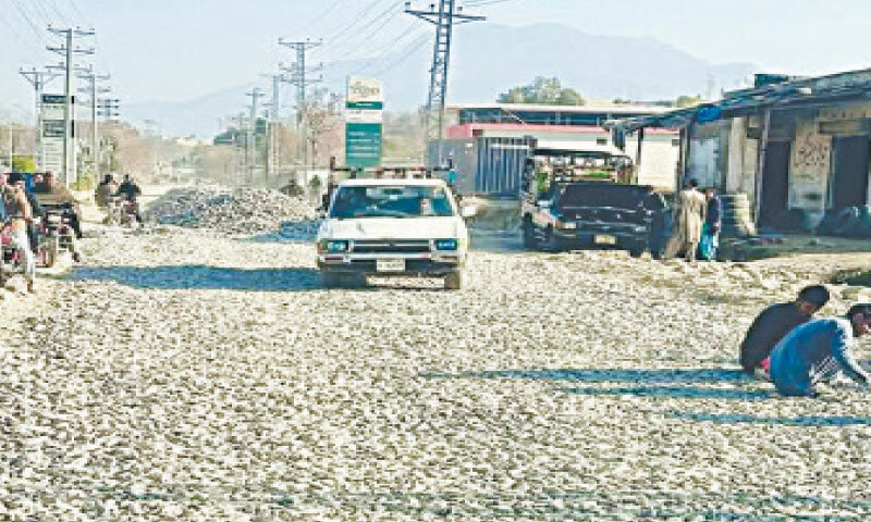 Car drives by unfinished road in Bajur. &mdash;Dawn