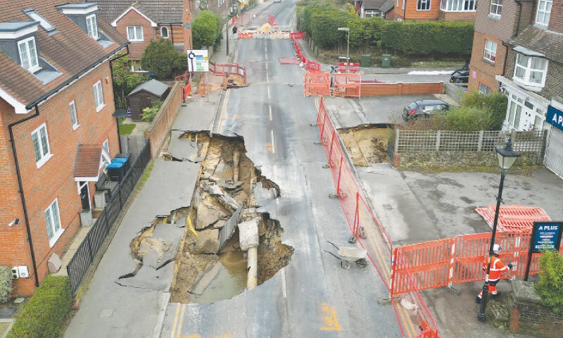 A DRONE view shows a worker walking near a large sinkhole in Godstone, on Wednesday.&mdash;Reuters
