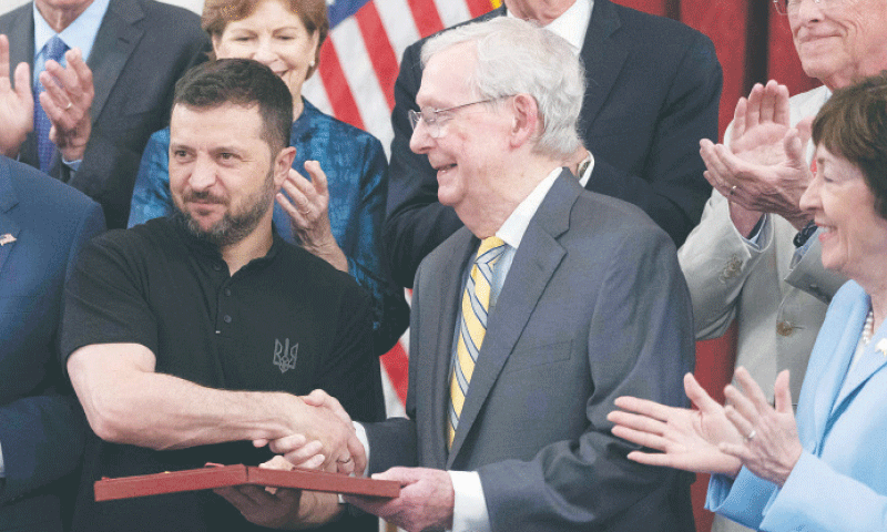 A July 10, 2024, file photo shows Ukrainian President Volodymyr Zelensky presenting a medal to US Senate Minority Leader Mitch McConnell (centre) on Capitol Hill.&mdash;AFP