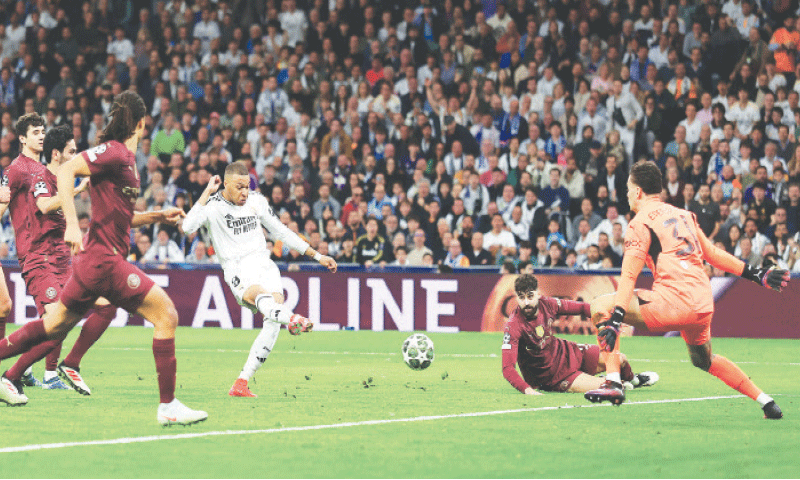 MADRID: Real Madrid&rsquo;s Kylian Mbappe (C) shoots to score past Manchester City goalkeeper Ederson during their Champions League play-off second leg at the Santiago Bernabeu Stadium.&mdash;Reuters
