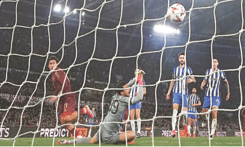 ROME: Paulo Dybala (L) of AS Roma scores past Porto goalkeeper Diogo Costa during their Europa League play-off second leg at Stadio Olimpico. &mdash; Reuters