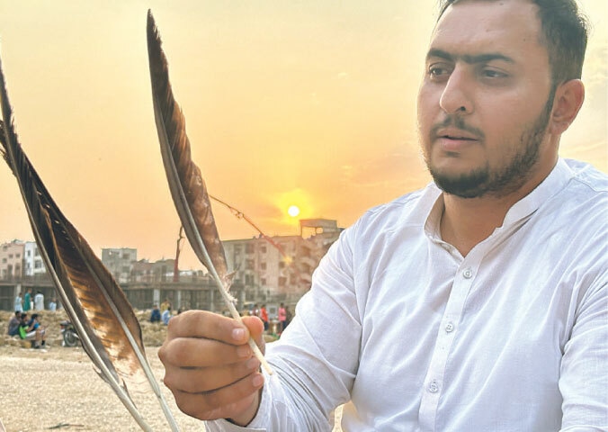 A Mukha player prepares a feather that is tied to arrows for adornment | Photo by the writer