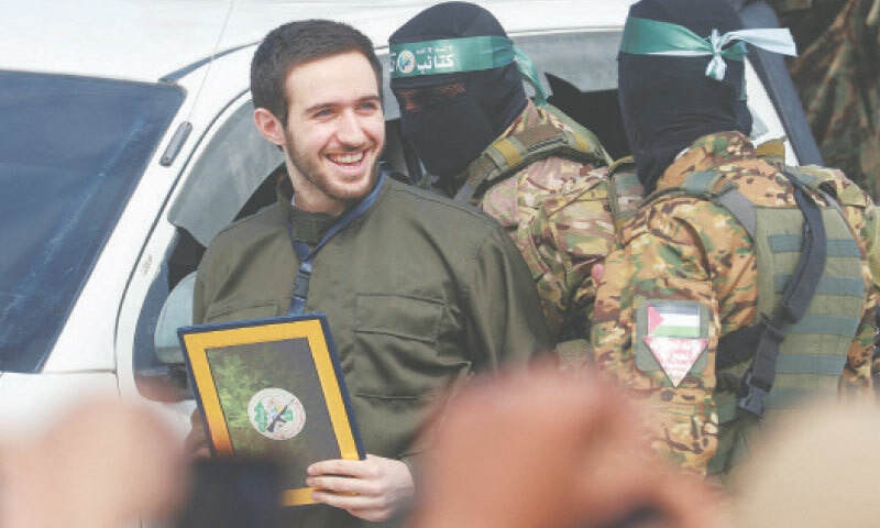 GAZA STRIP: Omer Shem Tov, a prisoner held in Gaza since the Oct 7, 2023 attack, is escorted by Hamas fighters as he is released in Nuseirat, on Saturday.—Reuters GAZA STRIP: Omer Shem Tov, a prisoner held in Gaza since the Oct 7, 2023 attack, is escorted by Hamas fighters as he is released in Nuseirat, on Saturday.—Reuters