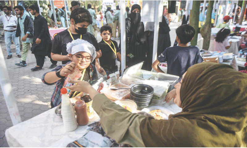 A young entrepreneur takes payment from a woman for selling pizza slices.
— Fahim Siddiqi / White Star A young entrepreneur takes payment from a woman for selling pizza slices.
— Fahim Siddiqi / White Star