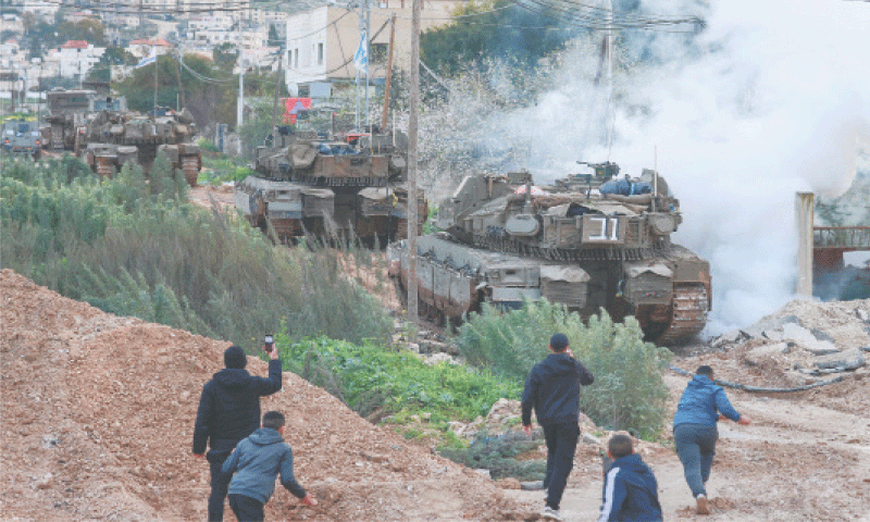 Palestinian youths throw stones at Israeli tanks 
and bulldozers entering the Jenin camp for Palestinian refugees in the occupied West Bank, on Sunday.
—AFP
