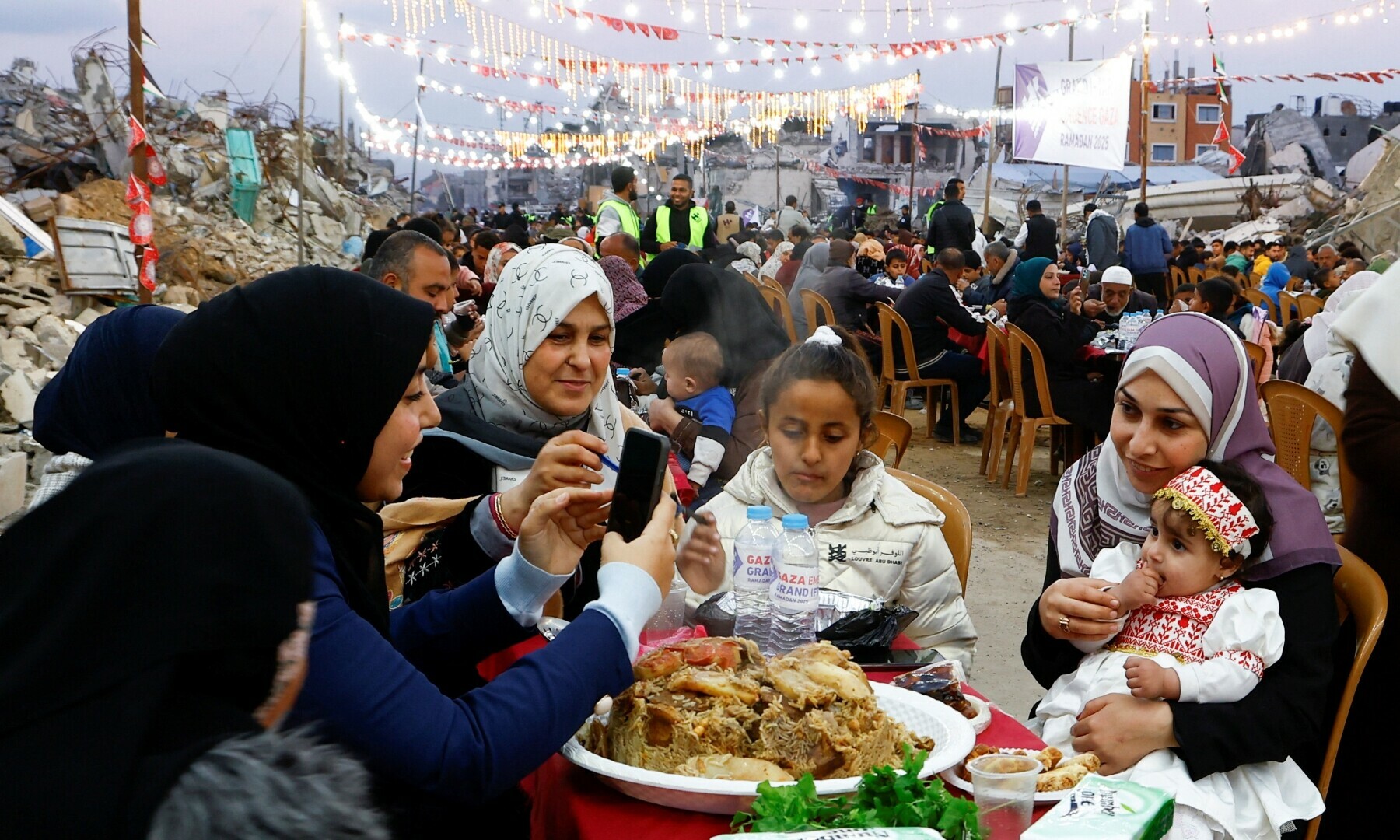 Palestinians break their fast by eating the Iftar meals during the holy month of Ramazan, near the rubble of buildings in Rafah, in the southern Gaza Strip on March 1, 2025. — Reuters/Hatem Khaled