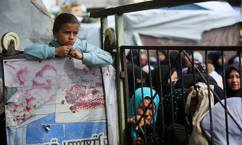 Palestinians gather to receive bread from a bakery, in Khan Younis, in the southern Gaza Strip on March 9. &mdash; Reuters