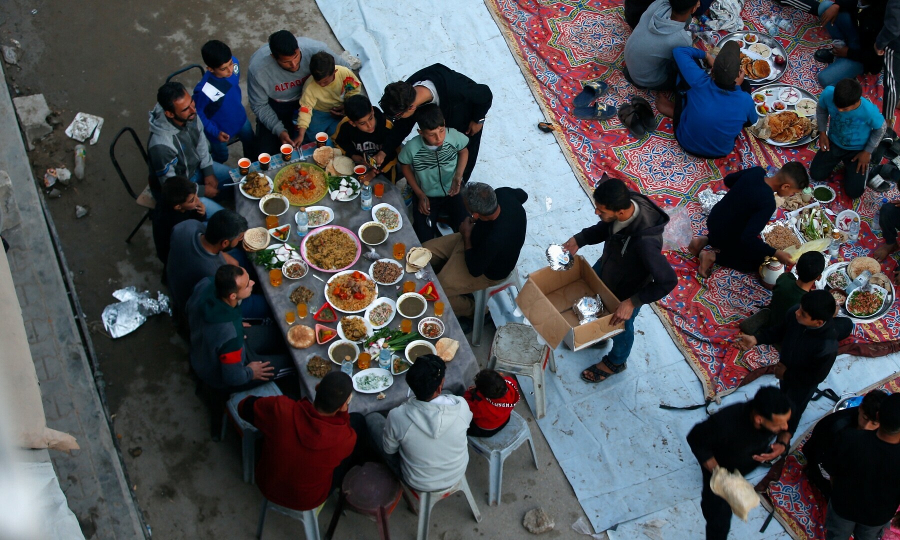  Palestinians break their fast by eating Iftar meals during Ramazan, near the rubble of buildings, in the northern Gaza Strip on March 15, 2025. &mdash; Reuters/Mahmoud Issa 