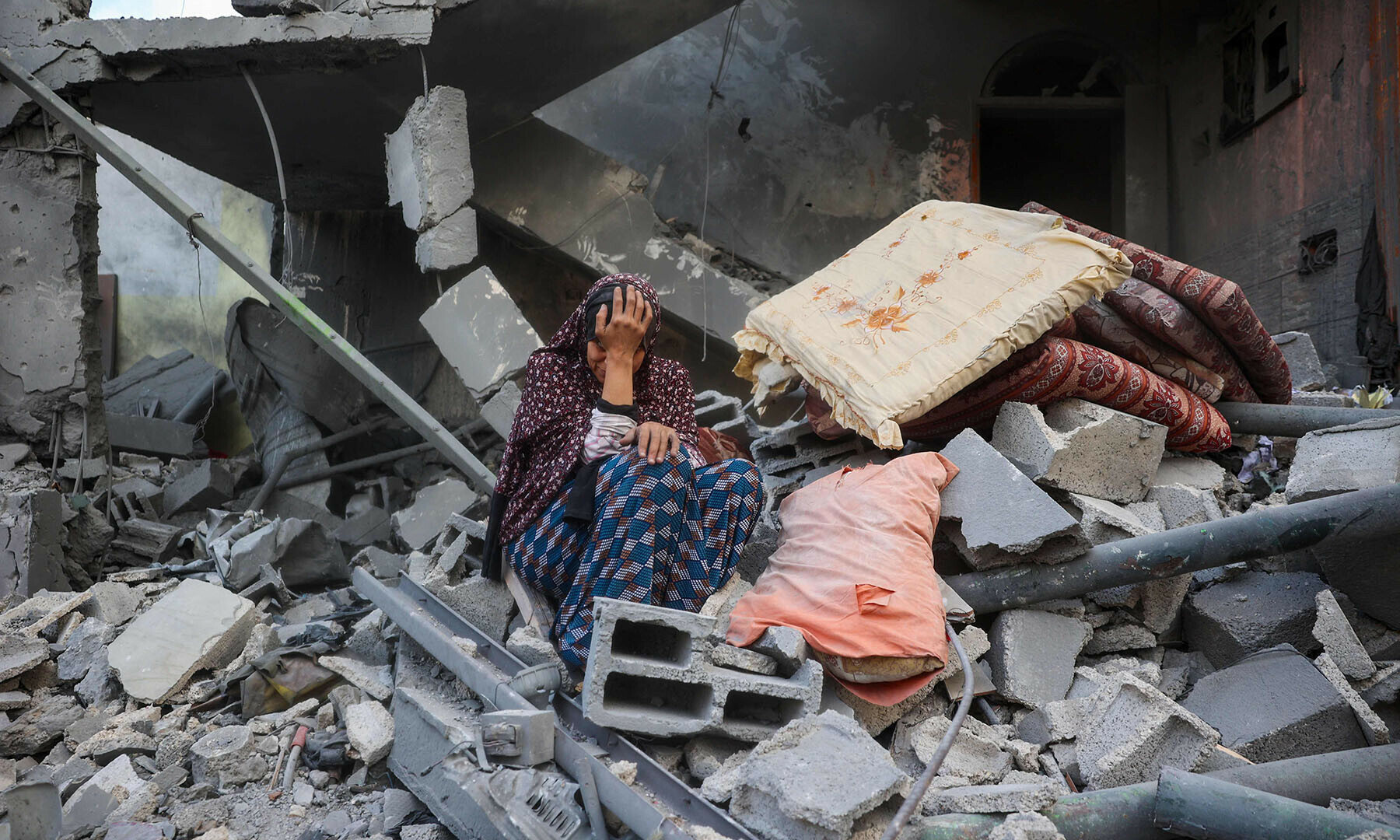 A woman cries while sitting on the rubble of her house, destroyed in an Israeli strike, in the Nuseirat refugee camp in central Gaza Strip on March 18. — AFP